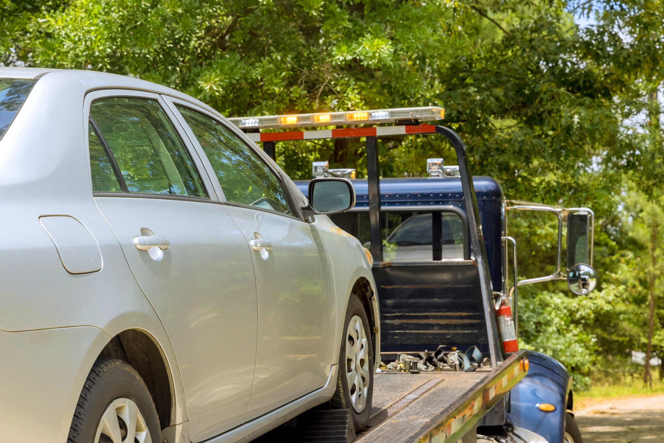 Tow truck towing a gray sedan