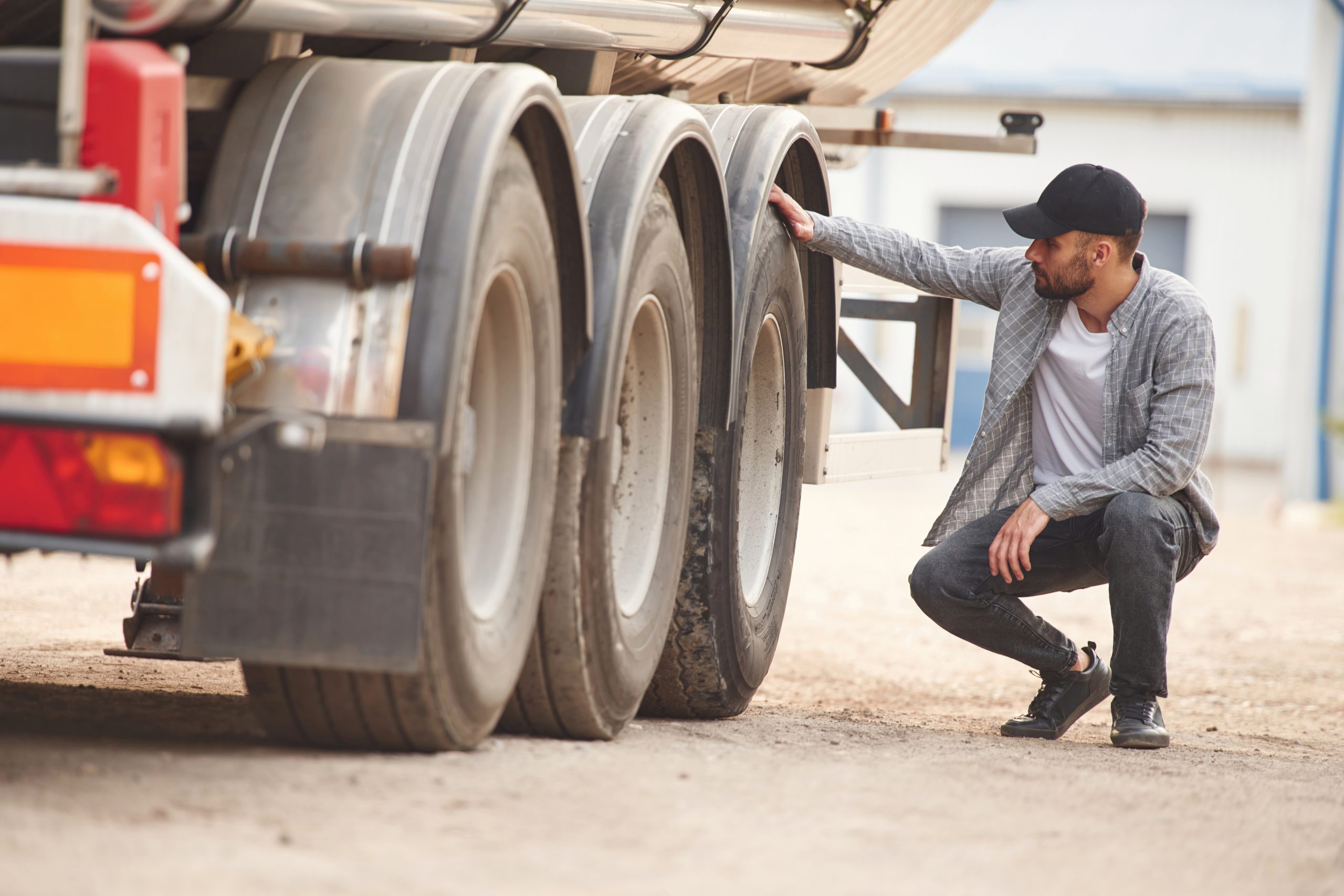 Trucker inspecting his truck tires for damages